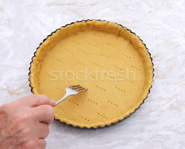 Woman finishes pricking holes in a pastry pie crust Stock photo © sarahdoow