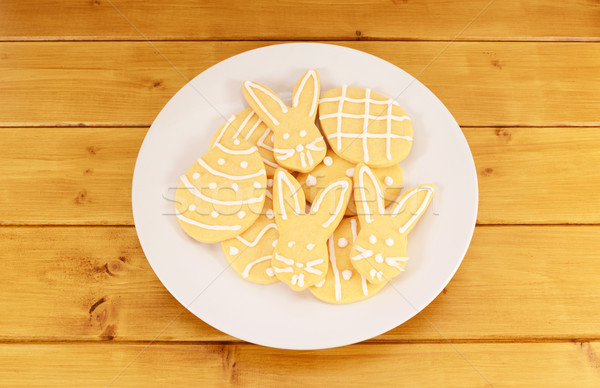 Plate full of frosted Easter cookies on a wooden table Stock photo © sarahdoow