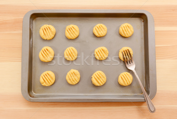Flattening balls of biscuit dough on a tray Stock photo © sarahdoow