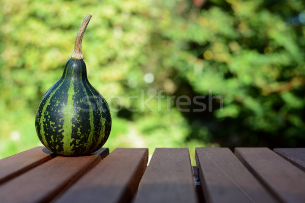 Green spinning ornamental gourd on wooden table  Stock photo © sarahdoow