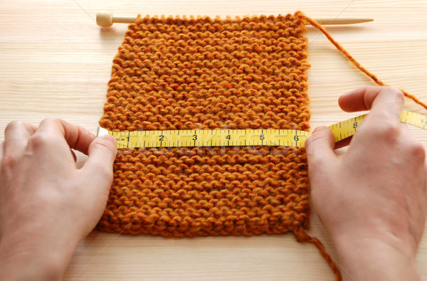 Two hands measuring knitting in inches Stock photo © sarahdoow