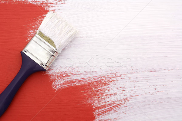 Paintbrush with white paint painting over red Stock photo © sarahdoow