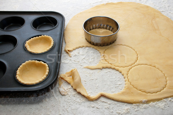Pastry circles being cut and filling a bun tin to make jam tarts Stock photo © sarahdoow