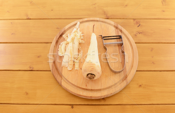 Peeled parsnip with vegetable peeler on a chopping board Stock photo © sarahdoow