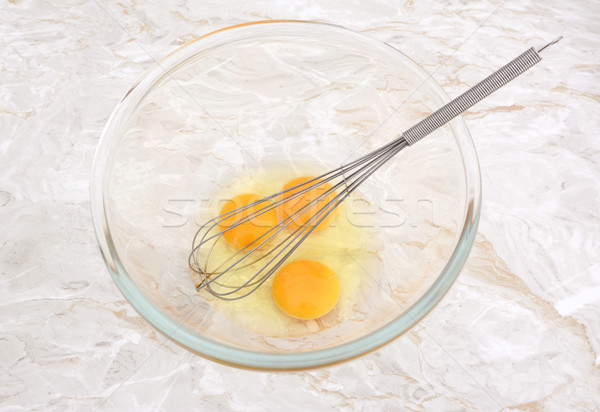 Three eggs in a glass bowl with a whisk Stock photo © sarahdoow