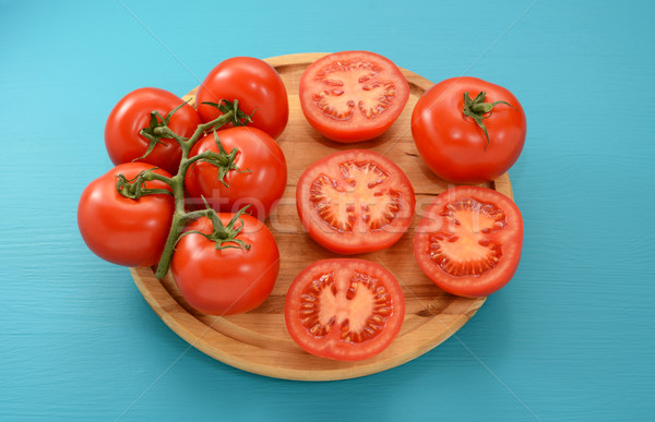 Tomatoes - on the vine, halved and whole on a wooden board Stock photo © sarahdoow
