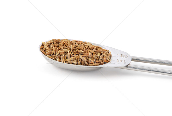 Whole cumin seeds measured in a metal teaspoon Stock photo © sarahdoow