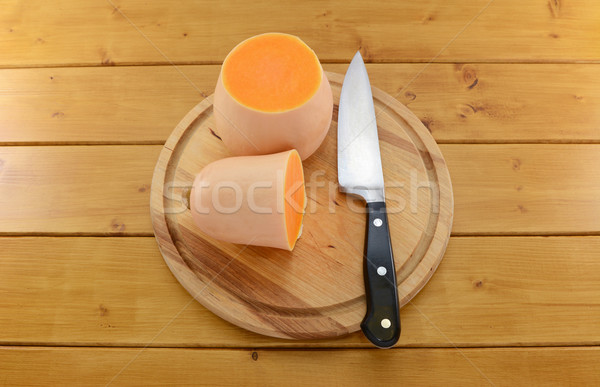 Butternut squash cut in half with a knife on a wooden board Stock photo © sarahdoow