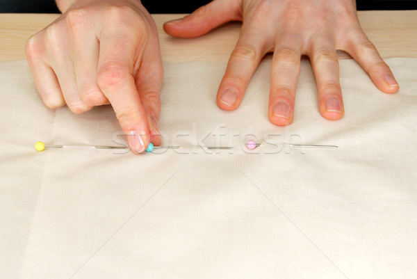 Closeup of large upholstery pins being pinned into plain fabric Stock photo © sarahdoow
