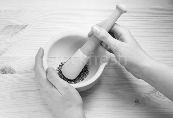 Two hands holding a pestle and mortar with whole coriander seeds Stock photo © sarahdoow
