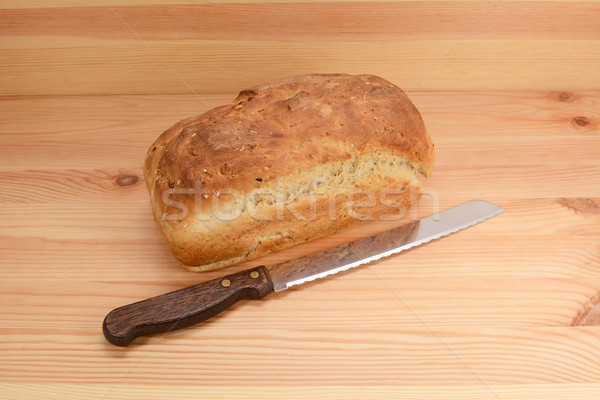 Stock photo: Fresh loaf of oat and linseed bread with a bread knife