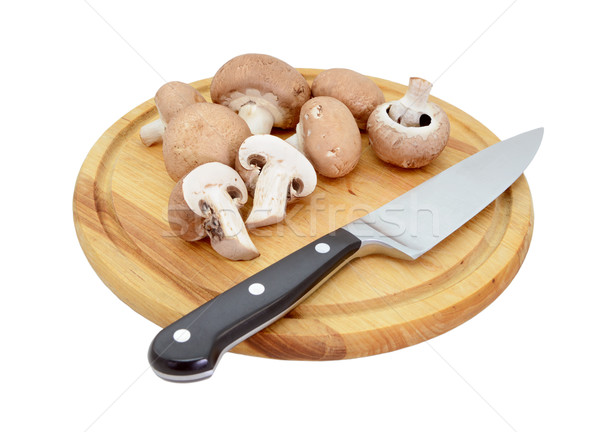 Whole and halved chestnut mushrooms on board with knife Stock photo © sarahdoow