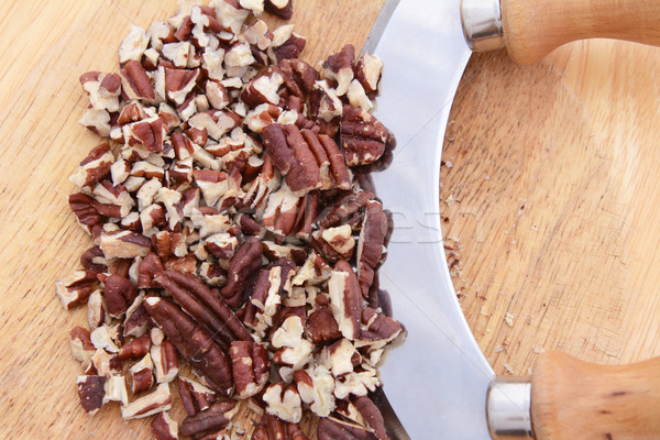 Stock photo: Chopped toasted pecans with a rocking knife