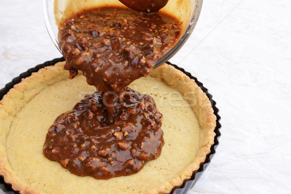 Pouring pecan pie filling into a pastry case Stock photo © sarahdoow