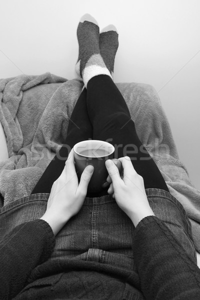 Woman holding a hot drink, relaxing with her feet up Stock photo © sarahdoow