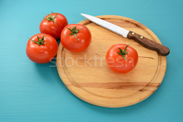 Tomatoes with a serrated knife on a wooden board Stock photo © sarahdoow