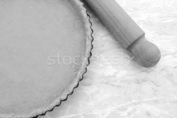 Stock photo: Baking tin lined with pastry, wooden rolling pin beside