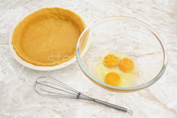 Bowl of eggs with a whisk and lined pie dish Stock photo © sarahdoow