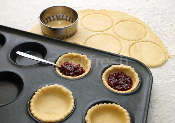 Cutting and filling pastry shapes to make jam tarts  Stock photo © sarahdoow