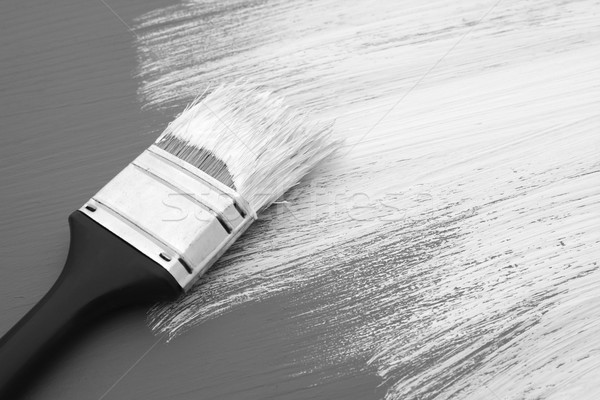 Dirty paintbrush with white paint on half-painted board Stock photo © sarahdoow