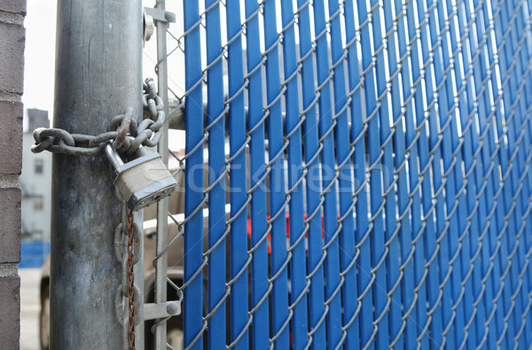 Heavy-duty padlock and chain on blue security gate Stock photo © sarahdoow