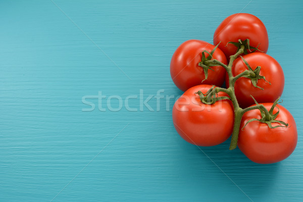 Five tomatoes on the vine on a blue background Stock photo © sarahdoow
