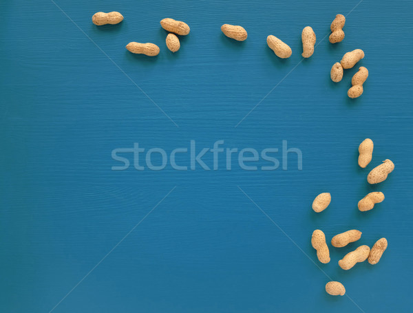 Monkey nuts scattered on a blue painted background Stock photo © sarahdoow