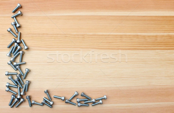 Socket head screws as L-shape border on woodgrain background Stock photo © sarahdoow