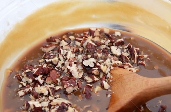 Wooden spoon stirring pecan nuts into pie filling Stock photo © sarahdoow