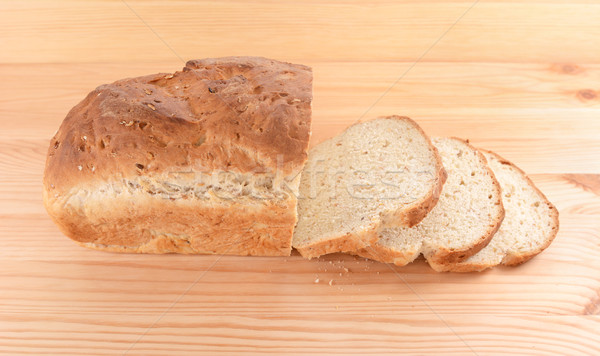 Crusty loaf of fresh bread and three slices Stock photo © sarahdoow
