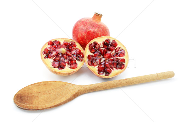 Pomegranate with two cut halves, with spoon for removing seeds Stock photo © sarahdoow