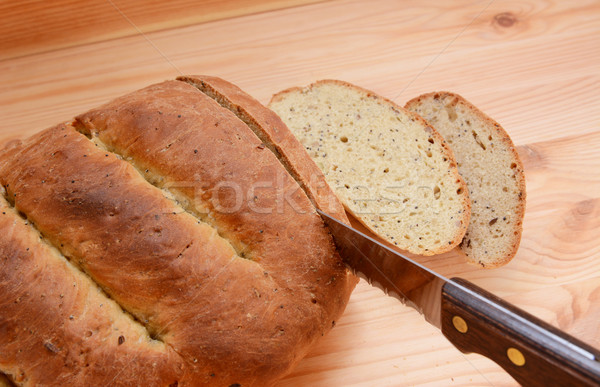 Cutting slices of bread on a wooden table Stock photo © sarahdoow