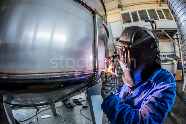 Man welding with reflection of sparks on visor. Hard job.  Stock photo © sarymsakov
