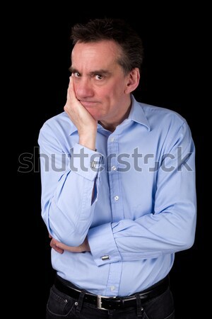 Angry Frowning Man Glaring over Hand on Chin Stock photo © scheriton