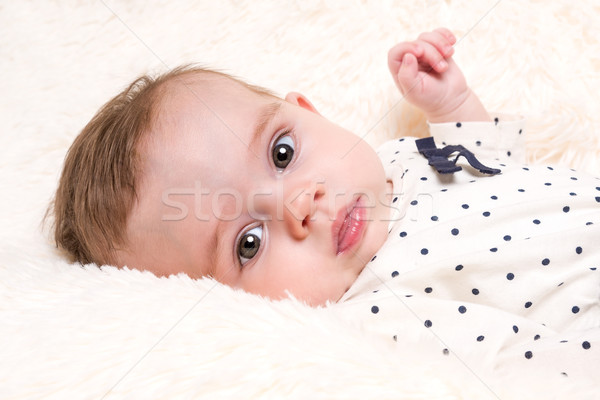Beautiful Baby Girl in Spotty Top on Cream Fur Rug Stock photo © scheriton