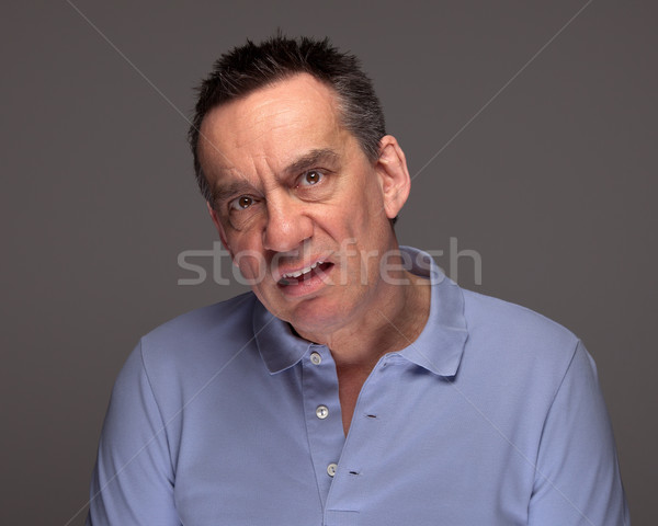 Stock photo: Man Pulling Unhappy Face on Grey Background