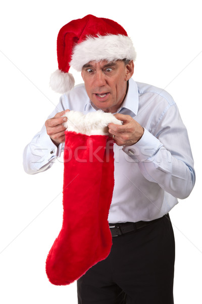 Business Man in Santa Hat Looking Surprised into Christmas Stocking Stock photo © scheriton