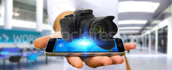 Młody człowiek nowoczesne kamery aparat cyfrowy telefonu komórkowego Zdjęcia stock © sdecoret