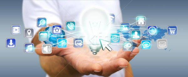 Businessman holding lightbulb with digital icons Stock photo © sdecoret