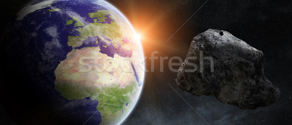 Stock photo: Asteroids threat over planet earth