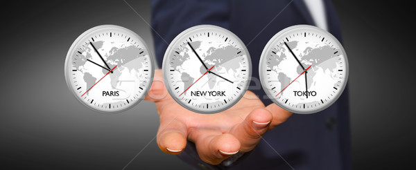 Businessman holding time of the world in his hand Stock photo © sdecoret