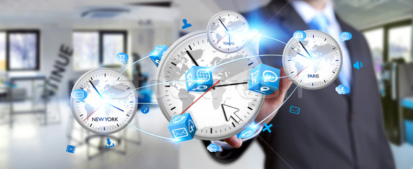 Businessman connecting time of the world in his hand Stock photo © sdecoret