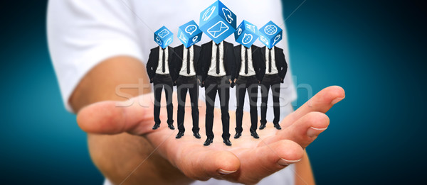 Stock photo: Man holding Group of businessmen in his hand with application ic
