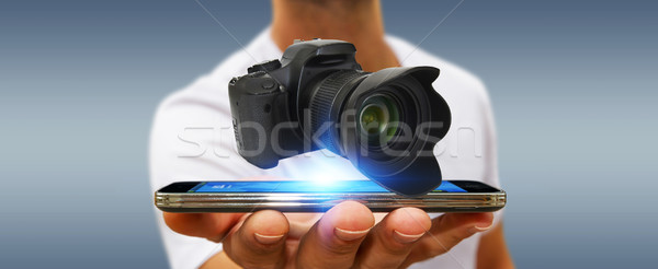 Młody człowiek nowoczesne kamery aparat cyfrowy telefonu komórkowego Zdjęcia stock © sdecoret