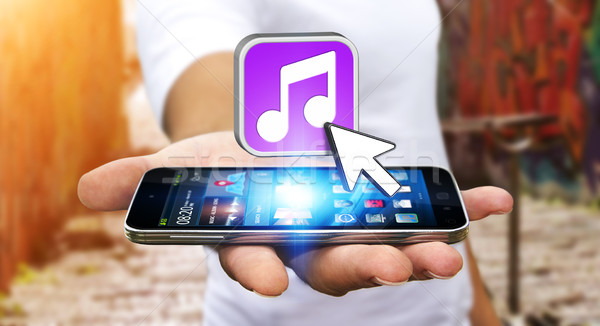 Young man using modern mobile phone to listen music Stock photo © sdecoret