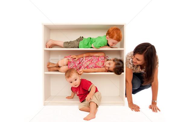 Kids playing hide and seek with mum on bookshelf Stock photo © sdenness