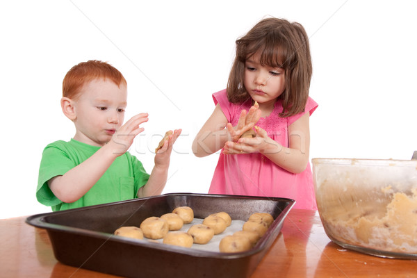 Kids rolling out chocolate chip cookies for baking Stock photo © sdenness