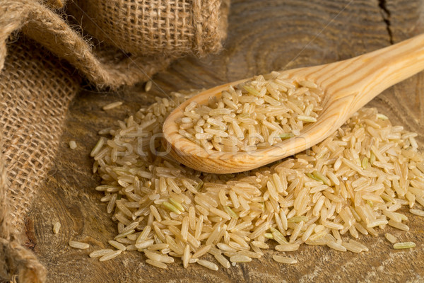 Natural brown uncooked rice on wooden spoon Stock photo © ShawnHempel