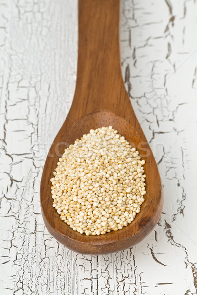 Raw unprocessed quinoa seeds in wooden spoon on white table Stock photo © ShawnHempel