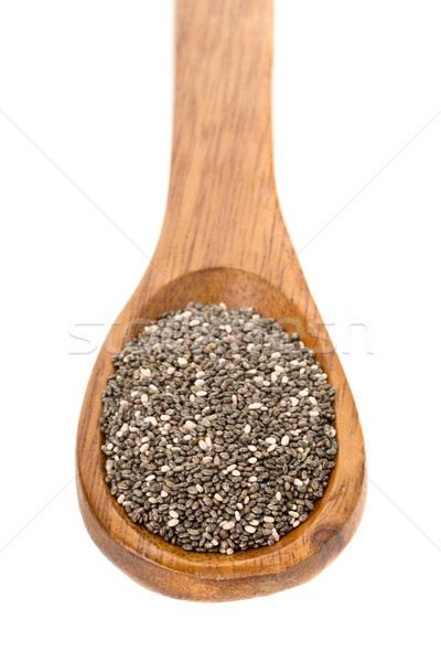 Whole dried black chai seeds in wooden spoon Stock photo © ShawnHempel